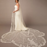 Clover Cut Regal Cathedral Veil with Organza Vines Bride wearing a long, elegant wedding veil with floral details on a plain background