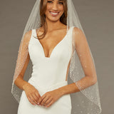 Fingertip Veil with Dense Scatter of Pearls Woman wearing a wedding dress with a veil against a brown background