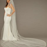 Wide Cathedral Veil with Dense Scatter of Pearls Woman wearing a wedding dress with a long veil on a brown background