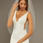 Reverse Pearl Scatter Bridal Veil Woman wearing a wedding dress with a sheer veil against a brown background
