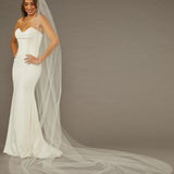 Reverse Pearl Scatter Bridal Veil Cathedral Length Woman wearing a wedding dress with a long veil against a brown background