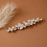 Bridal Bobby Pin with Marquise Jewels & Pearls A bridal hair claw clip decorated with faux pearls and clear marquise and round crystals, styled on a warm brown textured background with dried pampas grass.