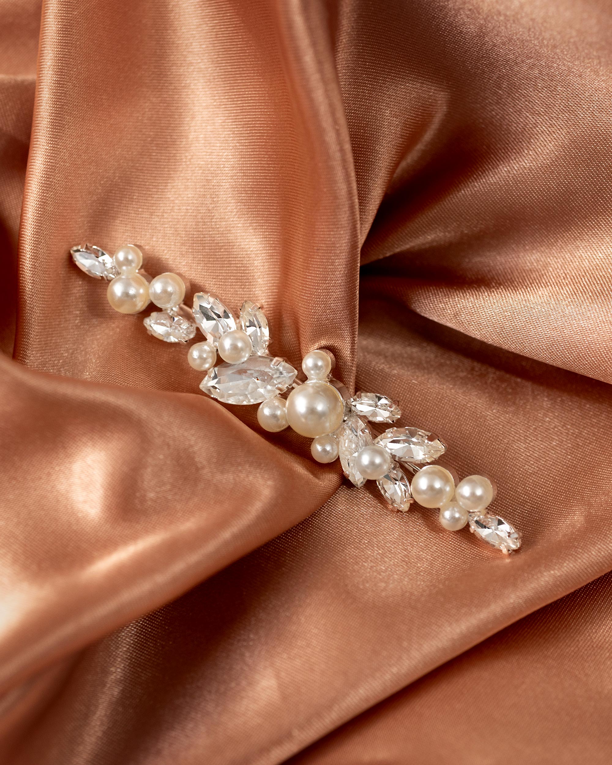Bridal Bobby Pin with Marquise Jewels & Pearls A pearl and crystal floral hair accessory brooch with silver-toned metal, displayed on draped rose gold satin fabric.