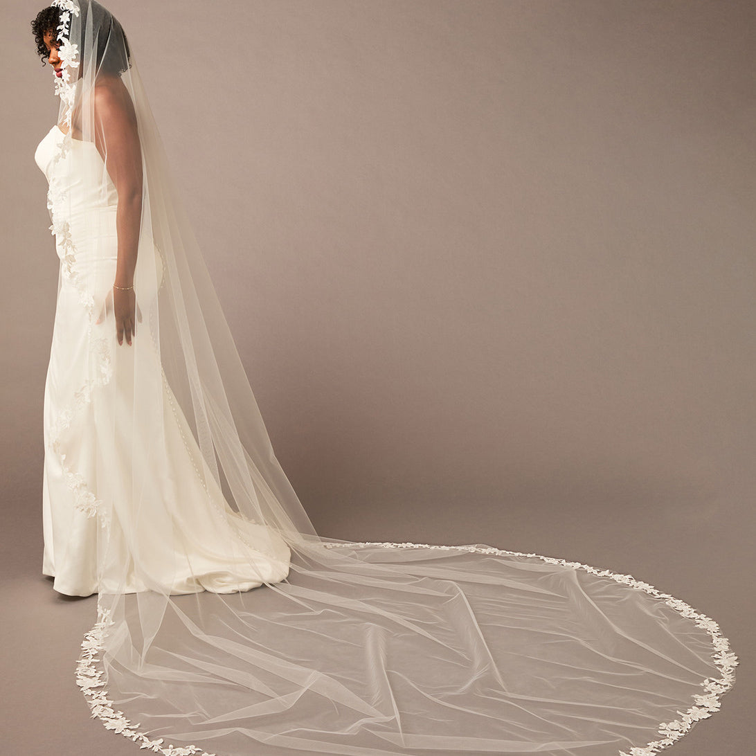 Mantilla Bridal Veil with Sequined Lace Woman wearing a long white wedding veil against a plain background