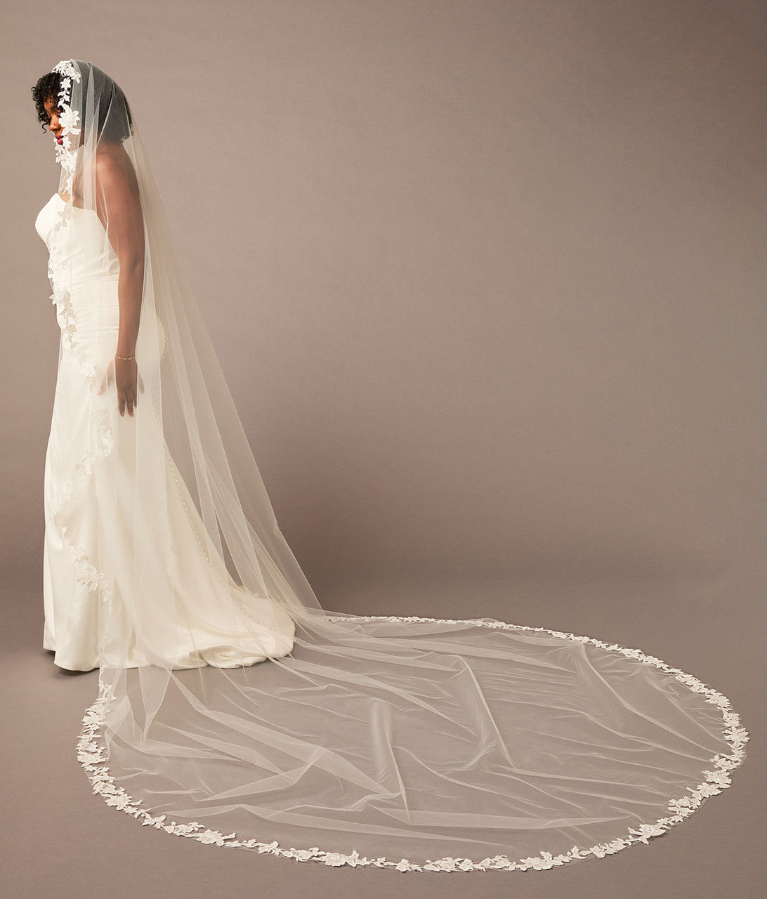 Mantilla Bridal Veil with Sequined Lace Woman wearing a long white wedding veil against a plain background