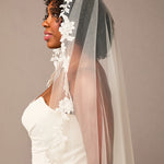 Mantilla Bridal Veil with Sequined Lace Woman wearing a white wedding dress with a floral veil against a plain background
