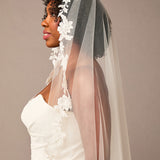 Mantilla Bridal Veil with Sequined Lace Woman wearing a white wedding dress with a floral veil against a plain background