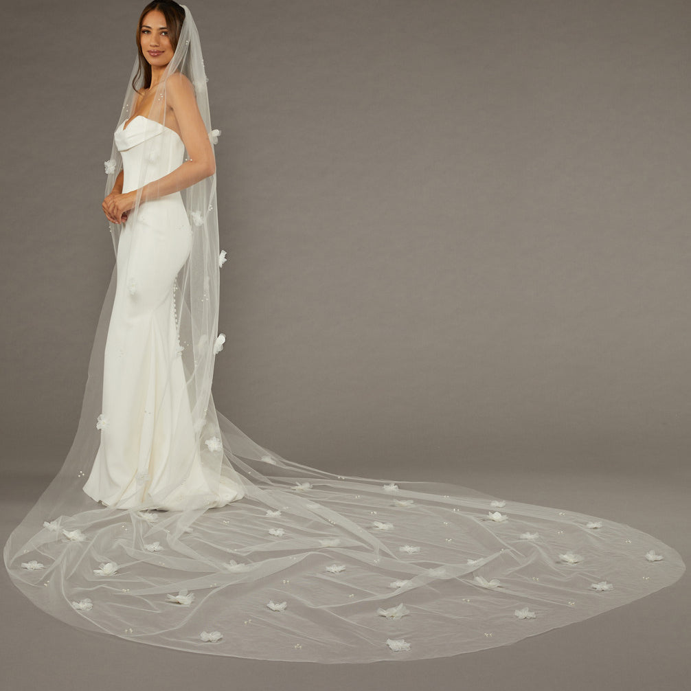Regal Length Wedding Veil with 3D Organza Flowers Bride wearing a long, elegant wedding veil against a plain background