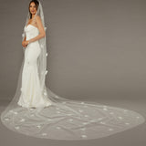Regal Length Wedding Veil with 3D Organza Flowers Bride wearing a long, elegant wedding veil against a plain background