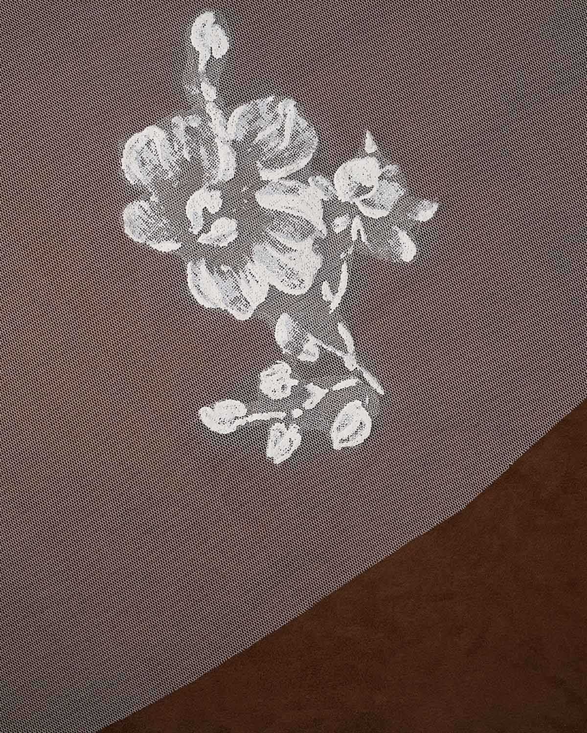 Bridal Luxe Veil with Painted Flowers Cassandra Lynne  A close-up of a sheer taupe mesh fabric with a white floral print, layered over a darker brown textured surface.