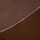 Wedding Veil with Crystal and Opaque Bead Trim A close-up of a brown textured fabric with a delicate silver beaded chain running diagonally across it.