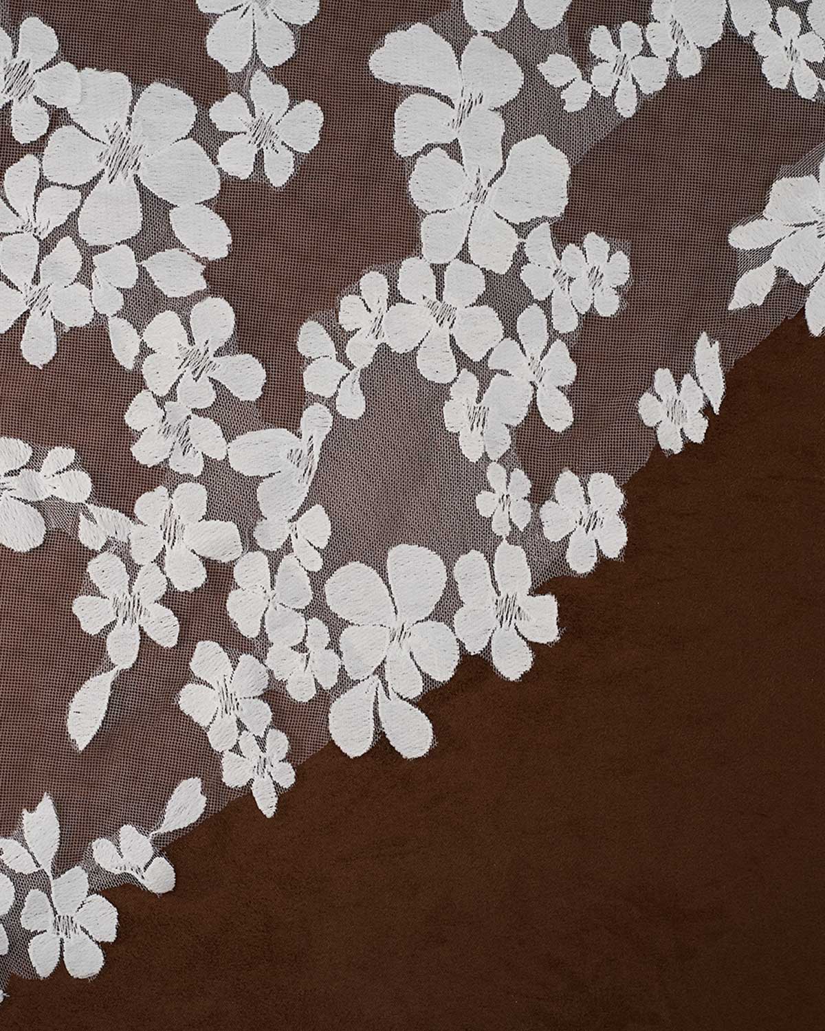 Light ivory floral lace trim with embroidered cherry blossom motifs over a sheer brown mesh, shown laid diagonally on a dark brown surface.