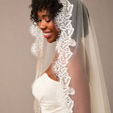 Luxe Tulle Lace Mantilla Fingertip Bridal Veil Woman wearing a white lace veil against a plain background