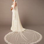 Woman wearing a white wedding dress with a long veil against a brown background Luxe Tulle Lace Mantilla Cathedral Bridal Veil