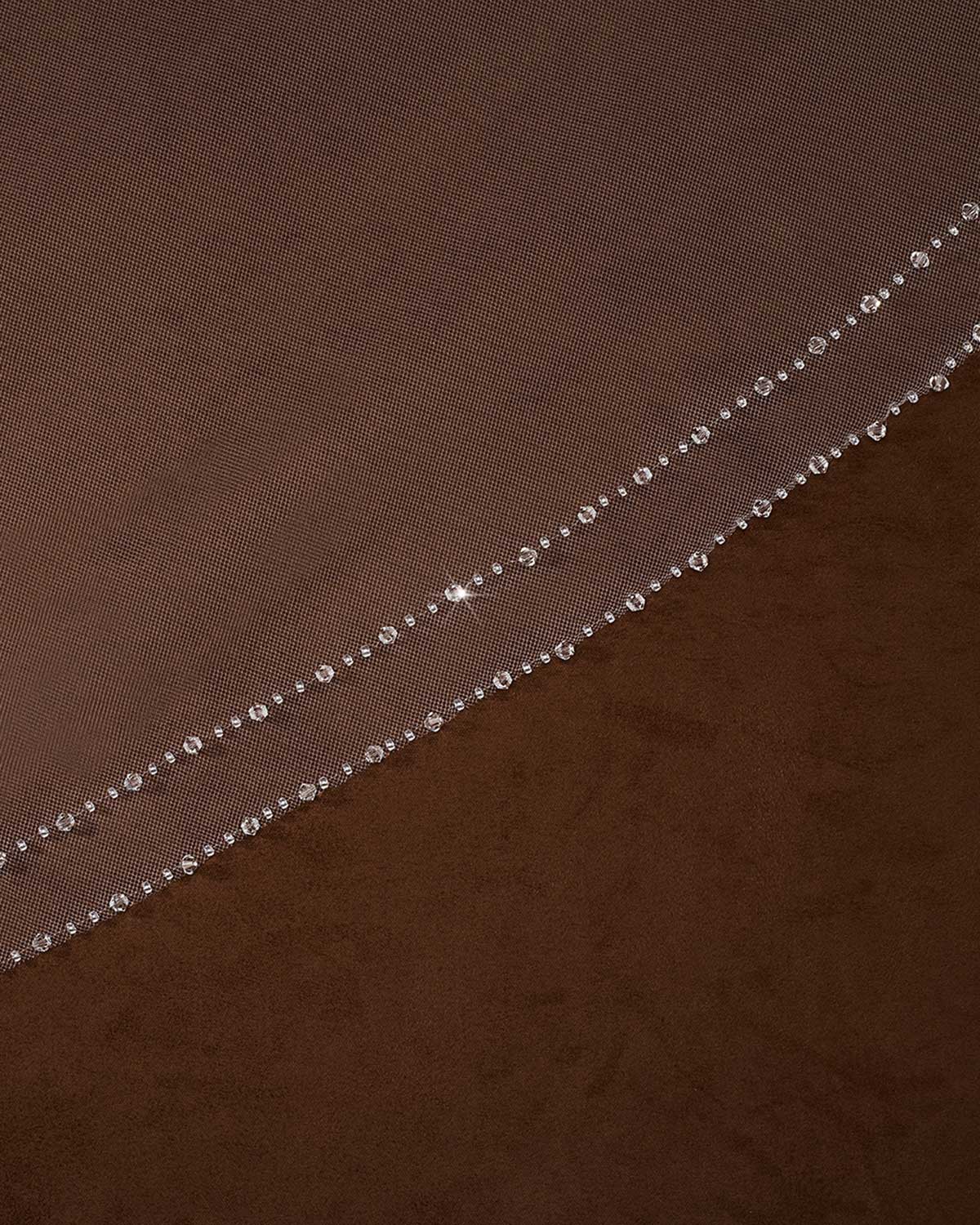 Bridal Veil with Double Crystal Trim Cassandra Lynne A close-up of a brown sheer mesh fabric with a delicate diagonal line of small clear rhinestones or beads along one edge.