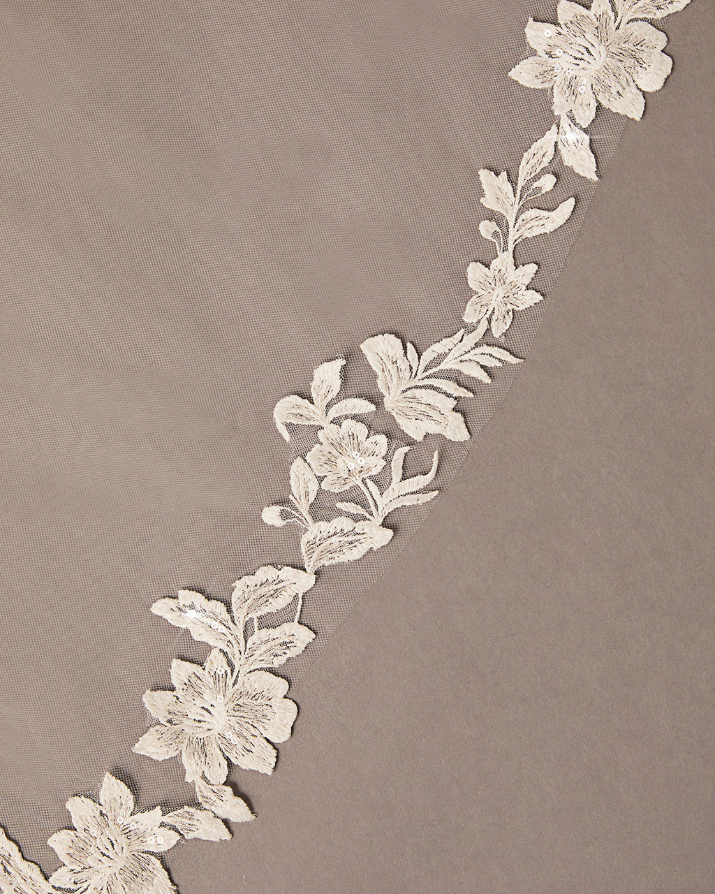 Mantilla Bridal Veil with Sequined Lace Decorative floral lace trim on a beige background