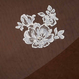 Bridal Veil with Painted Flowers and Pearls Cassandra Lynne -  Ivory painted embroidered floral lace applique on a brown sheer mesh fabric background.
