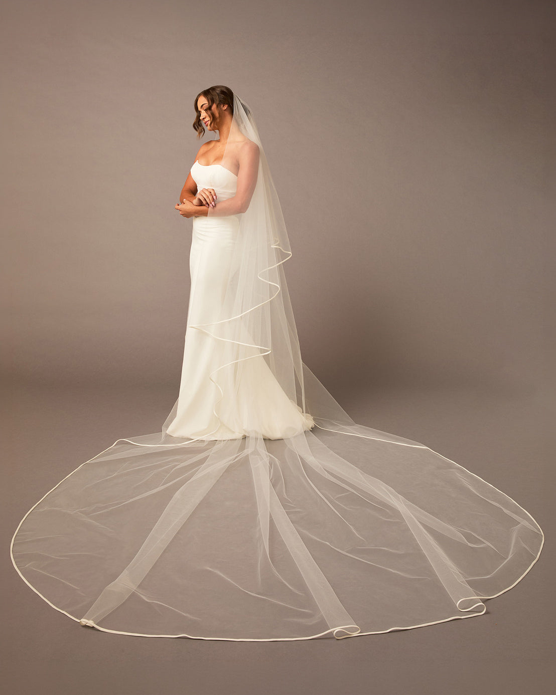 Royal Two Layer Mantilla Veil with Satin Trim Bride wearing a long veil against a plain background