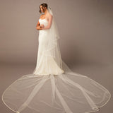 Royal Two Layer Mantilla Veil with Satin Trim Bride wearing a long veil against a plain background