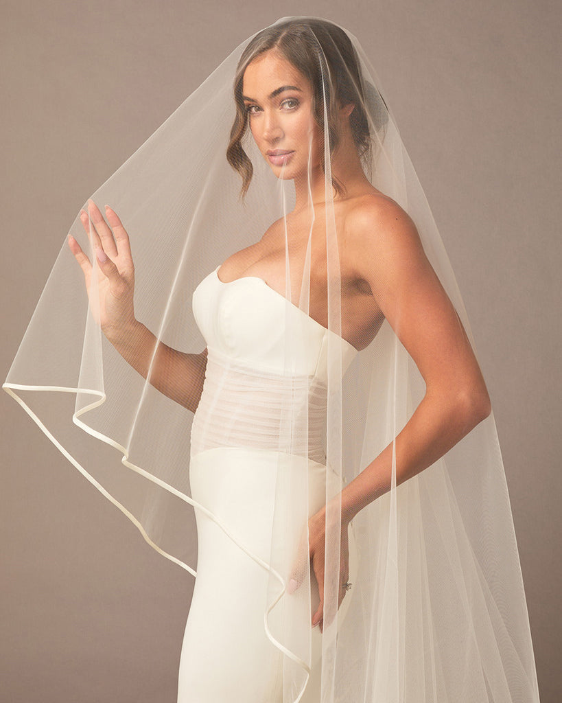 Royal Two Layer Mantilla Veil with Satin Trim Woman wearing a  wedding dress with a veil against a plain background