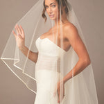 Royal Two Layer Mantilla Veil with Satin Trim Woman wearing a  wedding dress with a veil against a plain background