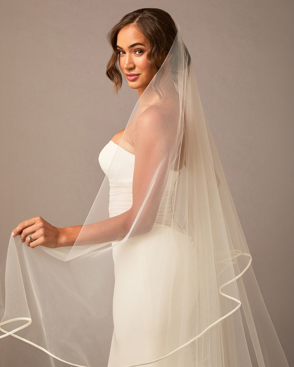 Royal Two Layer Mantilla Veil with Satin Trim Woman wearing a wedding dress with a long veil against a neutral background