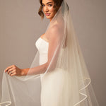 Royal Two Layer Mantilla Veil with Satin Trim Woman wearing a wedding dress with a long veil against a neutral background